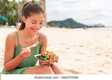 Woman Eating Poke Bowl Of Ahi Tuna On Waikiki Beach Hawaii. Local Food Fish Salad Vacation Travel. Asian Girl Happy Healthy Eat.