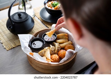 Woman Is Eating Prawns In Batter In A Bamboo Basket.
Traditional Japanese Food Eaten In A Restaurant.