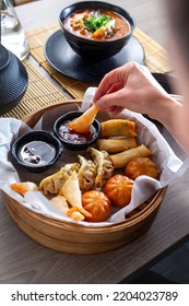 Woman Is Eating Prawns In Batter In A Bamboo Basket.
Traditional Japanese Food Eaten In A Restaurant.