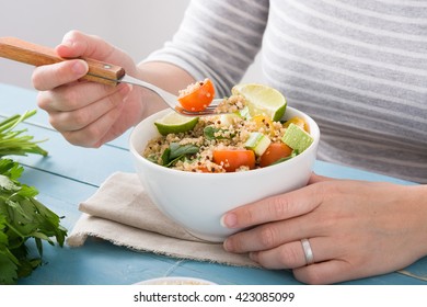 Woman Eating Quinoa  And Vegetables In Bowl
