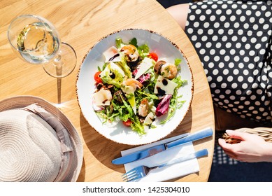 Frau, die Salat mit Garnelen auf der Sommerterrasse isst – Stockfoto