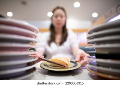 Woman Eating Salmon Sushi With Chopsticks