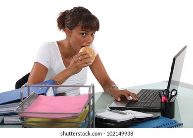 Woman Eating Sandwich At Desk