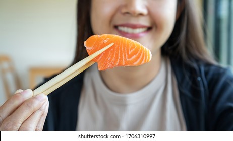 Woman eating a sashimi salmon.