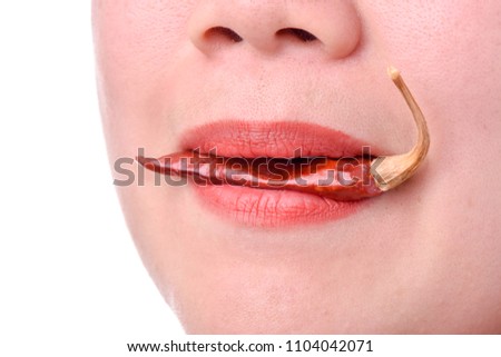 Woman eating a spicy red hot pepper on a white background