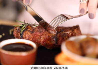 woman eating steak in a restaurant