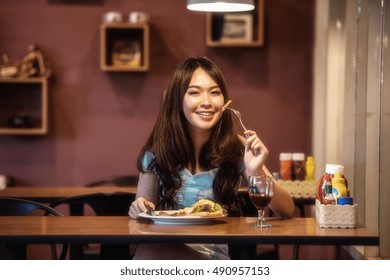 Woman eating steak in a restaurant