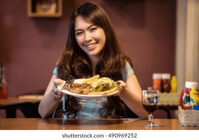 Woman Eating Steak In A Restaurant