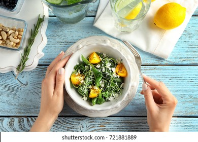 Woman Eating Superfood Salad With Tomatoes And Spinach At Table