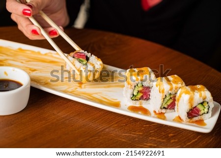 woman eating sushi in cafe