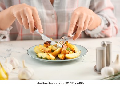 Woman Eating Tasty Baked Potato With Garlic On Light Background