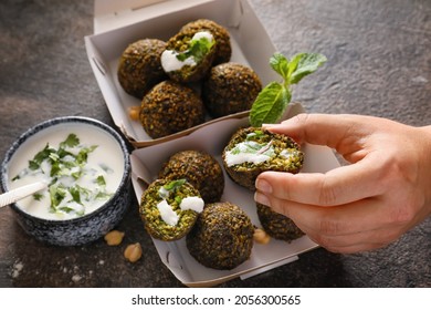 Woman Eating Tasty Falafel Balls With Sauce On Dark Background