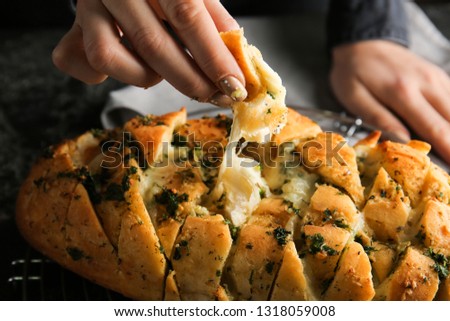 Woman eating tasty garlic bread, closeup