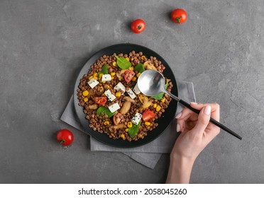 Woman Eating Tasty Lentils With Vegetables And Cheese, Top View