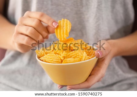 Woman eating tasty potato chips, closeup