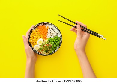 Woman eating tasty rice poke bowl on color background - Powered by Shutterstock