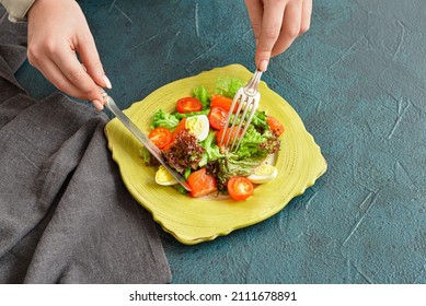 Woman Eating Tasty Salad With Salmon And Vegetables At Table