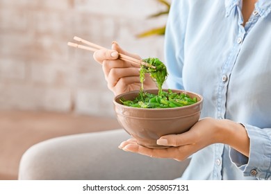 Woman eating tasty seaweed salad, closeup