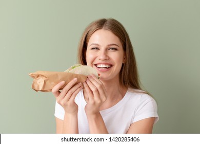 Woman Eating Tasty Taco On Color Background