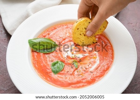 Woman eating tomato cream soup