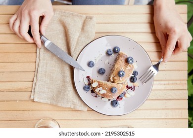 Woman Eating Traditional Pancakes With Fresh Blueberries And Agave Syrup On A Plate. Breakfast Outside.