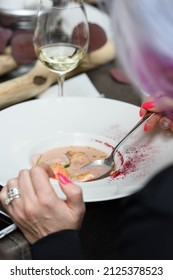 Woman Eats Fish Cream Soup With Salmon, Cheese And Herbs In White Soup Bowls