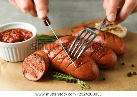 Woman eats grilled sausages, close up and selective focus