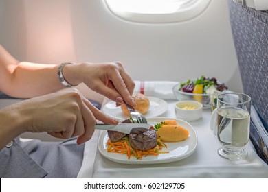 Woman Eats Lunch In Travel Aboard Of International Flight