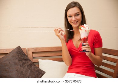 Woman Eats Sweet Strawberry Fruit Salad On A Bench Outdoor In Bar