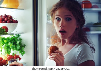 woman eats sweets at night to sneak in a refrigerator - Powered by Shutterstock