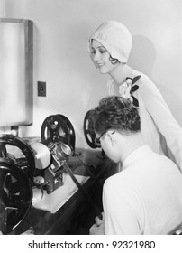 Woman At An Editing Machine With An Editor Reviewing Film