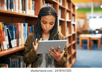 Woman, education and tablet in library for reading, research and studying in university. Female student, technology and ebook by bookshelf for learning, social media and online for information - Powered by Shutterstock