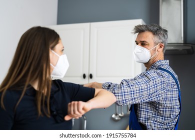 Woman Elbow Bump With Repair Man Or Handyman In Face Mask