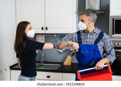 Woman Elbow Bump With Repair Man Or Handyman In Face Mask