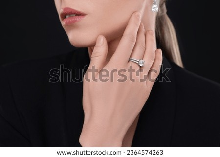 Woman with elegant jewelry on black background, closeup
