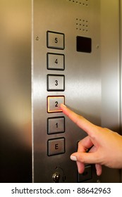 Woman In Elevator Or Lift Is Pressing The Button To Get Into The Right Floor; Only Hand To Be Seen - Close-up