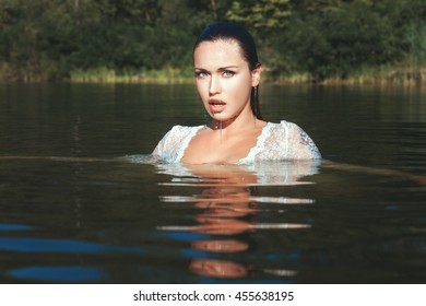 455638195. Woman emerged from under the water, drops dripping from her face...