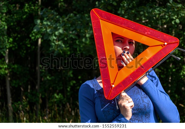 Woman with emergency stop sign vote on the road.\
Car insurance concept