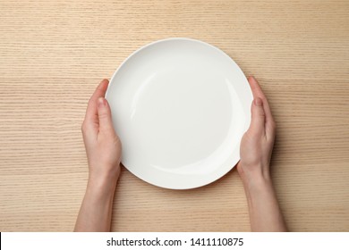 Woman With Empty Plate At Wooden Table, Top View