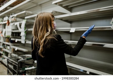 Woman With Empty Shelves In A Supermarket During Coronavirus Pandemic