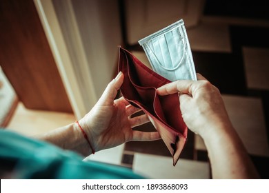 Woman With An Empty Wallet In Her Hands. Context Of Lack Of Money Due To Coronavirus. The Woman Opened The Wallet, And It Is Empty