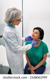 Woman Endocrinologist Palpates Of Woman's Neck For Diagnostics Of Thyroid Diseases. Thyroid Gland Exam And Treatment