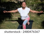 A woman engages in an outdoor yoga session, performing a warrior pose under the bright sun, showcasing tranquility and balance.