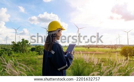 a woman engineer is wearing a protective helmet on her head, using tablet Analytics engineering data.	