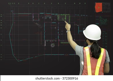 Woman engineer working on blueprint in office 
