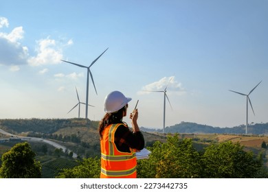 Woman engineer working  wind turbine site, renewable energy and technology concept, engineer working outdoor at daytime - Powered by Shutterstock