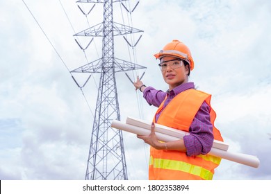 Woman Engineers Construction Worker Checking Layout On Digital Ipad Or Computer. Foreman Working  At Construction Site With Electric Tower Background.