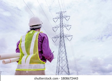 Woman Engineers Construction Worker Checking Layout On Digital Ipad Or Computer. Foreman Working  At Construction Site With Electric Tower Background.