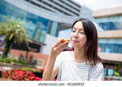 Woman enjoy egg tart at outdoor