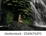 Woman enjoy huge green tropical watefall. Active travel with hiking